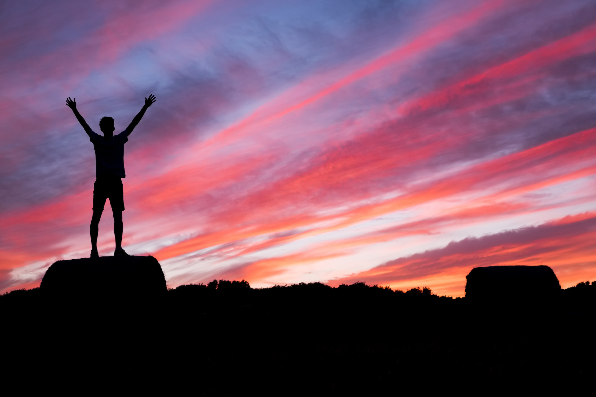 Man reaching the top of a mountain and celebrating